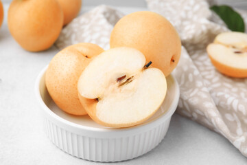 Naklejka na ściany i meble Bowl with delicious apple pears on white table