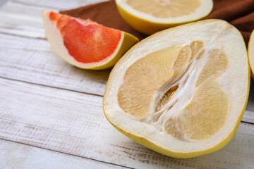 Different sorts of tasty pomelo fruits on white wooden table, closeup. Space for text