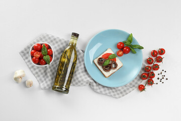 Fototapeta na wymiar Delicious sandwich with cream cheese, anchovies and tomatoes on white table, flat lay
