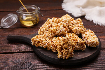 Board with puffed rice bars (kozinaki) on wooden table