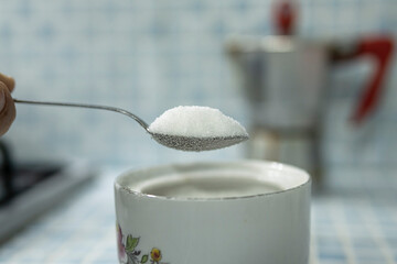 Close up view of a spoon full of rafined white sugar, hyperglycemia health care concept