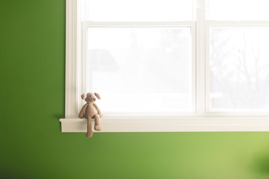 Teddy bear on window sill at home