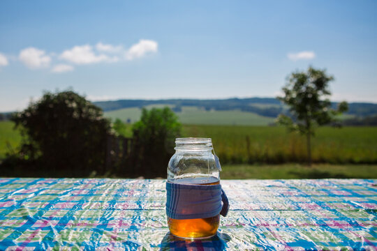 Close-up of ice tea in jar on table during sunny day