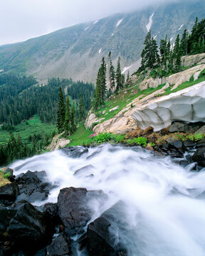 A waterfall flows out of Lake Isabelle in early Spring in the Indian Peaks WIlderness, Colorado.