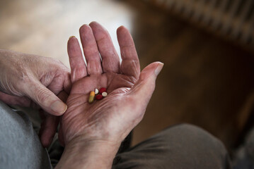 Close-up of senior man holding tablets in palm of hand