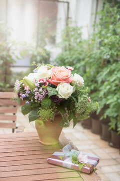 Gift with bouquet of flowers on table in garden, Munich, Bavaria, Germany