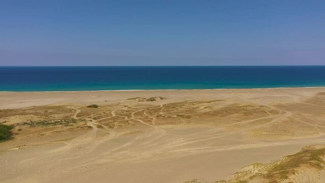 Sandy beach and blue ocean. Paoay Sand Dunes, Ilocos Norte, Philippines.