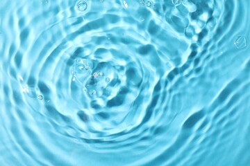 Closeup view of water with rippled surface on light blue background