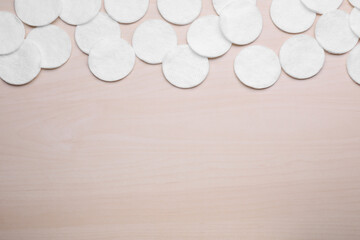 Fototapeta na wymiar Many clean cotton pads on wooden table, flat lay. Space for text