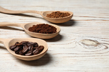 Spoons with instant, ground coffee and roasted beans on white wooden table, closeup