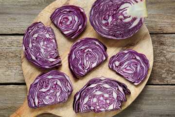 Tray with slices of fresh red cabbage on wooden table, flat lay