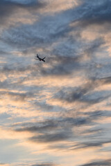 Airplane shape flying with sunset sky with colorful clouds