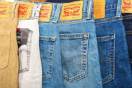 Levi's 511 jeans. Row of multi-colored branded pants. Selective focus.