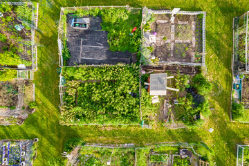 Aerial view of the community based modern urban farming and organic family gardens with various...