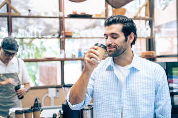 Caucasian attractive man drinking hot coffee from waiter in cafe shop. 