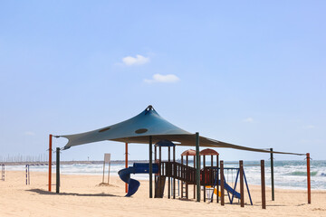 Children's playground with slide on beach