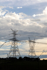 Silhouette of electric power towers during dusk in countryside of Brazil