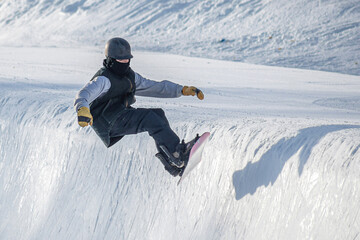 People are enjoying half-pipe skiing / snowboarding	