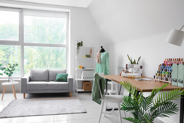 Fototapeta premium Interior of light atelier with tailor's workplace, mannequin and sofa