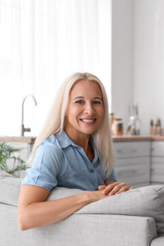 Mature Woman Sitting On Sofa In Kitchen