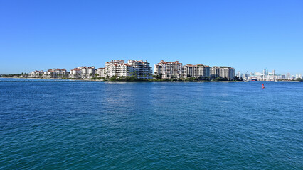 Fototapeta premium Fisher Island condominiums off South Beach in Miami Beach, Florida on clear cloudless sunny morning.