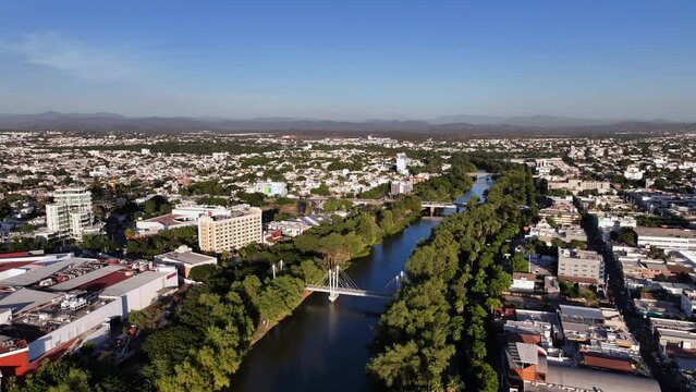 Aerial overview of the R&iacute;o Tamazula river, in sunny Culiacan, Mexico - circling, drone shot