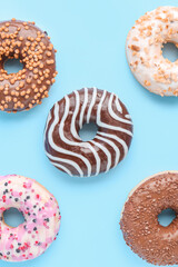 Different delicious donuts on color background