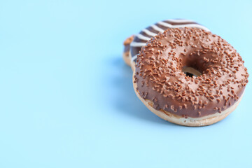 Sweet chocolate donuts on color background