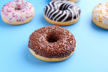 Sweet glazed donuts on color background, closeup