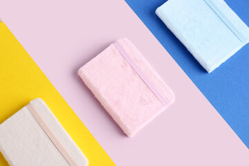 Stylish notebooks on colorful background