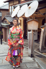 Japanese tourist girl in red Kimono traditional dress walking in walking street at Gion Temple area