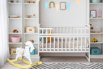 Stylish interior of children's room with baby bed