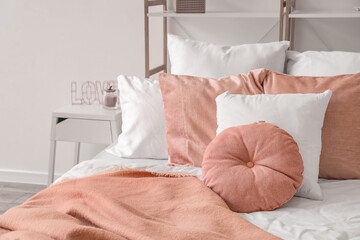 Big bed with soft pillows in light bedroom decorated for Valentine's Day, closeup