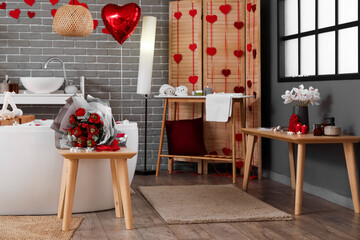 Interior of bathroom decorated for Valentine's Day with flowers and bathtub