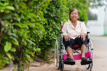 senior woman sitting in wheelchair at park