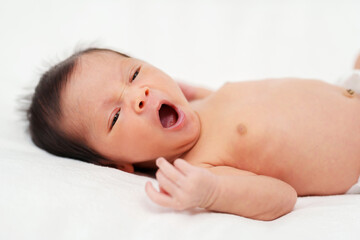 newborn baby yawning on bed
