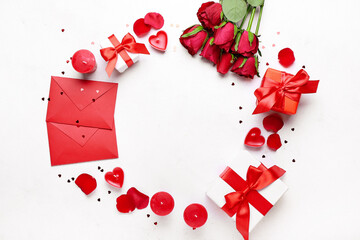 Frame made of beautiful candles, gift boxes and envelopes on light background. Valentine's Day celebration