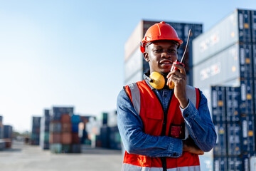 Black male african american engineering in uniform walkie talkie checking containers loading. Area logistics import export and shipping.