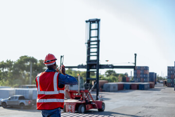 Foreman using radio communication control loading containers in shipping yard, for logistics and...