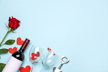 Fototapeta na wymiar Bottle of wine, rose flower and glasses on blue background. Valentine's Day celebration
