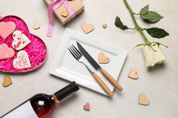 Fototapeta na wymiar Table setting with bottle of wine, rose flower, gift and cookies on white background. Valentine's Day celebration