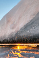 Transparent ice and icicles on the shore. lakes after frosts. icicles on the lake shore. Icicles on the shore of a frozen lake. Selective focus. 