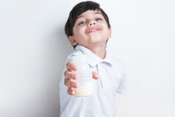 Cute boy in white shirt on white background - drinking fermented milk