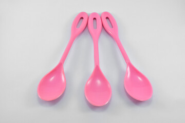 small pink plastic spoon isolated on white background.