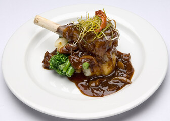 Braised lamb shank with mashed potatoes, broccolini and a mushroom sauce.