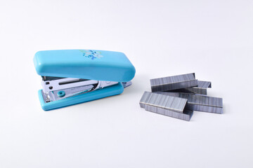 Office stationary Blue stapler and staples isolated on white background