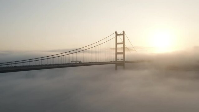 Foggy morning with sun rays shining through Tsing Ma Bridge in Hong Kong.