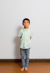 Cute little boy in casual outfit on background