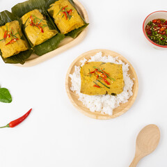 Hor Mok,Steamed fish with curry paste in banana leaf  (Thai language called Hor mok) on old wooden Thai steamed curry fish in banana leaf cups decorated with red chilli, (Hor Mok Pla)