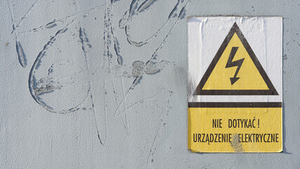 Schild mit der polnischen Aufschrift: Nie Dotykac ! Urzadzenie Elektryczne. Nicht berühren! Elektrisches Gerät - obrazy, fototapety, plakaty